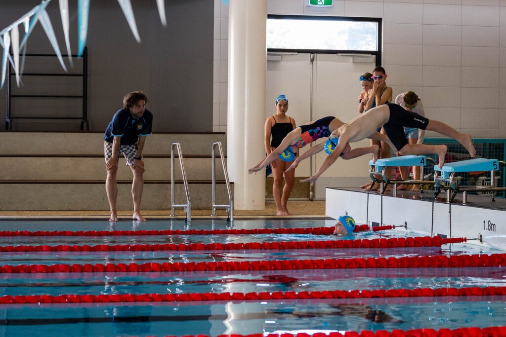 Two children diving into the swimming pool taking part in the Margaret River Swim School.